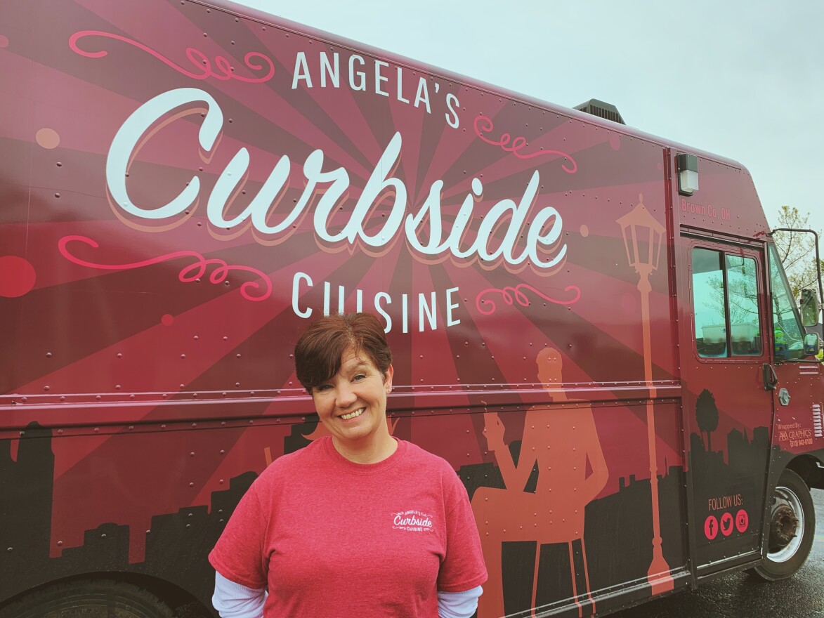 Angela Applegate poses in front of a food truck she renovated with her husband.